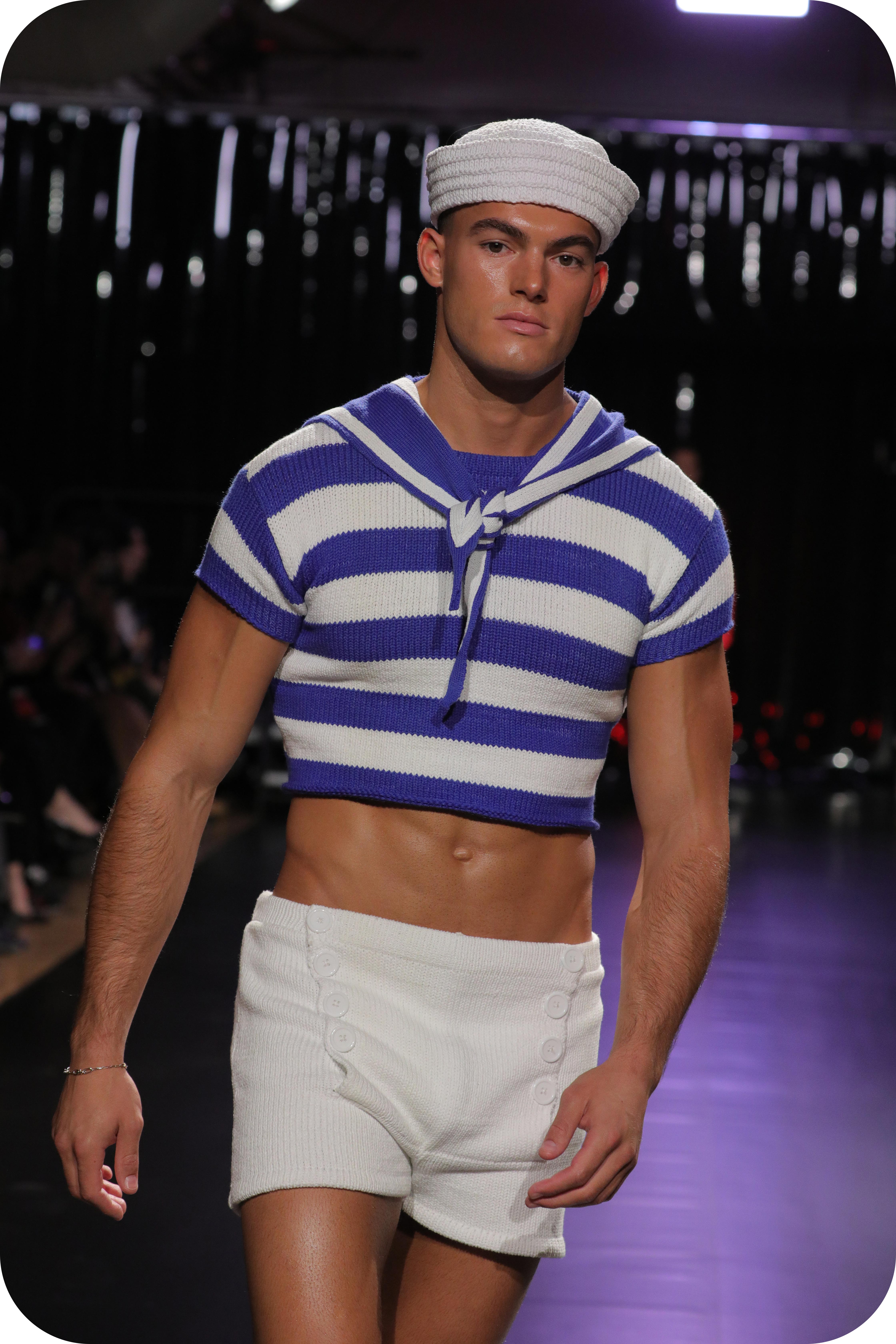 A man wearing a blue and white sailor outfit made of gay wool