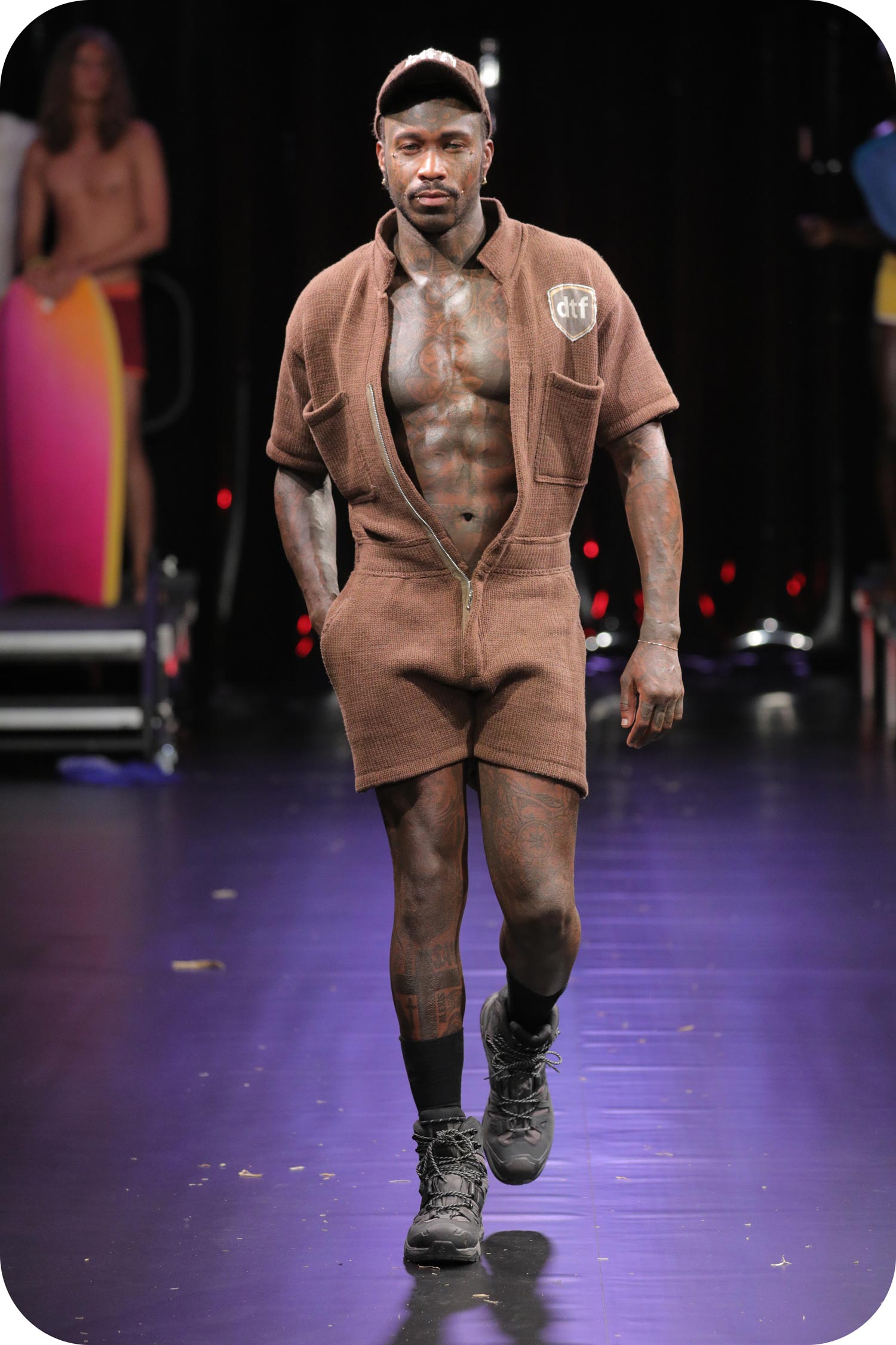 A man wearing a short brown onesie made of gay wool