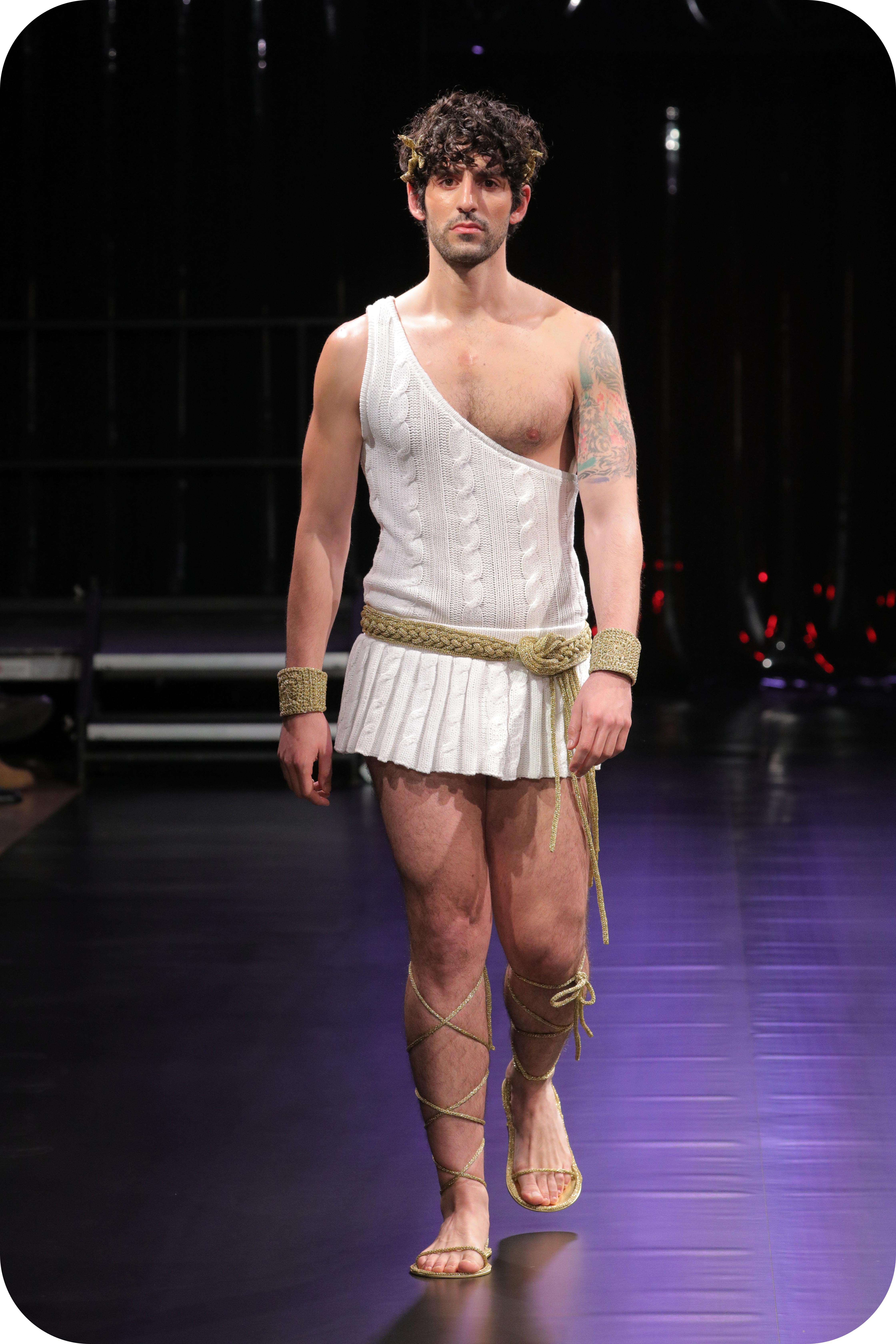 A man wearing a white greek god inspired outfit made of gay wool